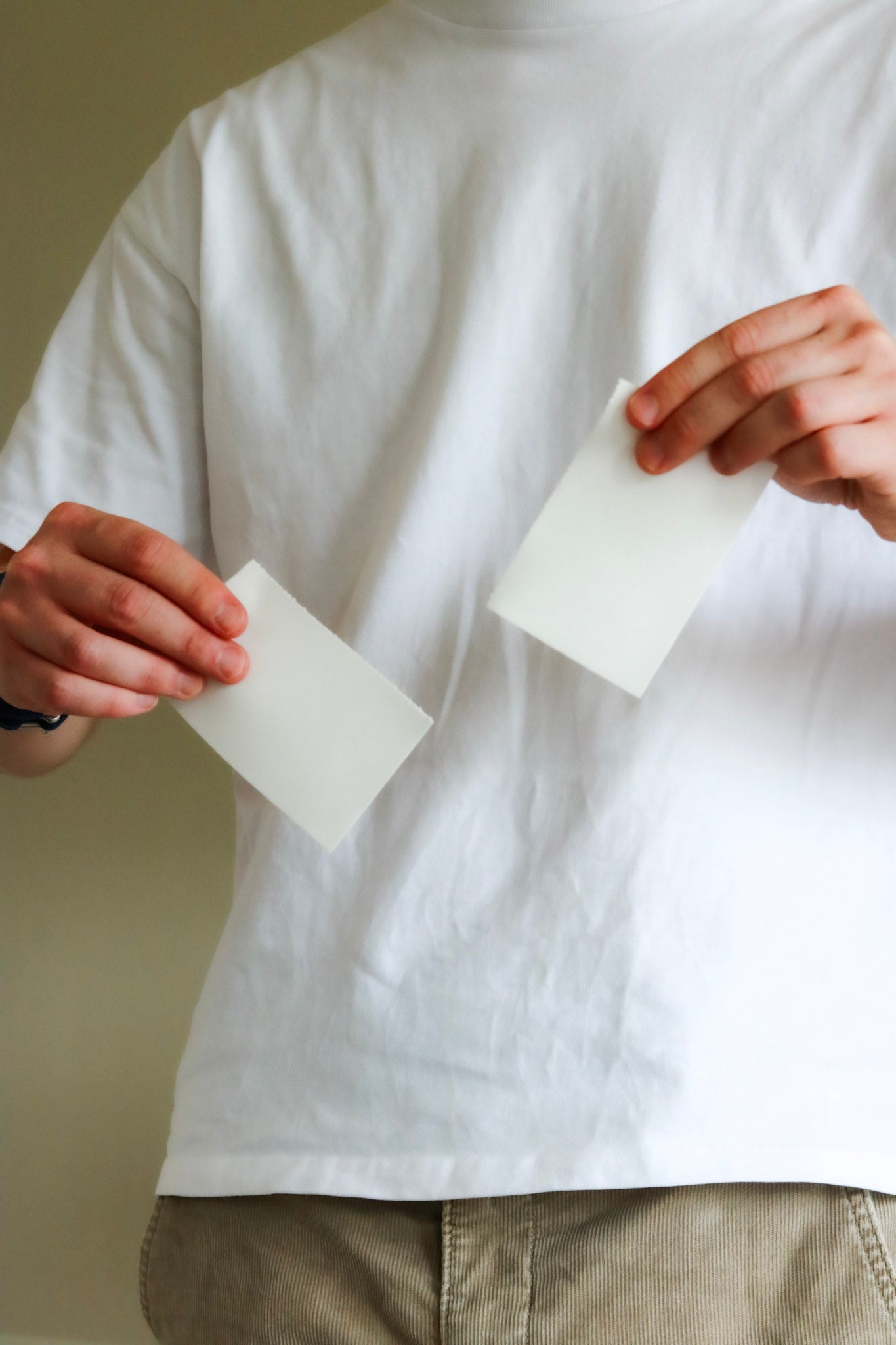Twee witte wasstrips in handen van gebruiker – eenvoudig doseren en biologisch afbreekbaar wasmiddel alternatief voor duurzaam wassen